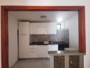 uma cozinha com armários brancos e uma bancada em Apartmani Franceska em Bol
