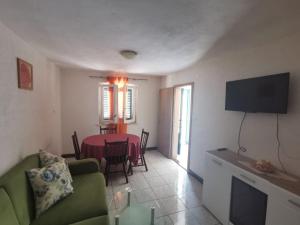 a living room with a green couch and a table at Apartmani Franceska in Bol