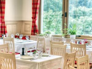 a dining room with white tables and chairs and windows at Hotel-Gasthof Neumühle in Thiergarten