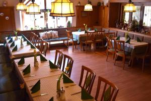 a restaurant with many tables and chairs and lights at Hotel Gasthof Zum Löwen in Velburg