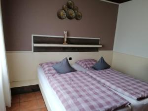 a bedroom with two beds with blue pillows at Hotel Haus Hildegard - Garni 3 Sterne superior in Niederkrüchten