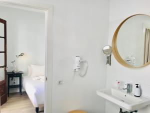Baño blanco con lavabo y espejo en El Hotelito 27, en Santa Cruz de la Palma