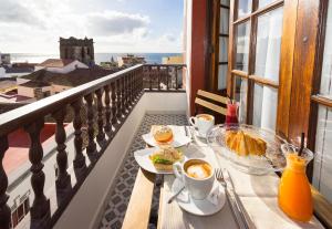 uma mesa com comida e café numa varanda em El Hotelito 27 em Santa Cruz de la Palma