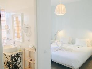 a white bedroom with a sink and a bed at El Hotelito 27 in Santa Cruz de la Palma