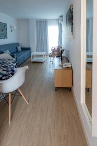 a living room with a blue couch and wooden floors at Apartamentos Buensol in Torremolinos