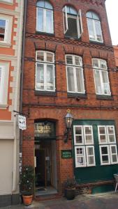 リューネブルクにあるHOTEL alt lüneburger Kutscherstubenの赤レンガ造りの緑の扉