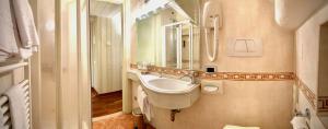 a bathroom with a toilet, sink, and mirror at Albergo Ristorante Gardesana ***S in Torri del Benaco