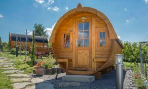 a small wooden cabin with a door in a yard at Muellers Weingut und Weinstube im Auerberg in Nordheim