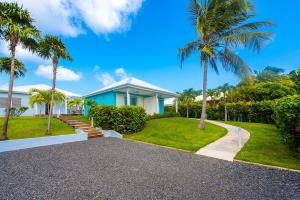 a house with palm trees and a driveway at Hôtel La Christophine in Saint-François