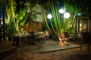 a restaurant with a table and chairs and palm trees at Hôtel Restaurant La Ribaudière in Antananarivo