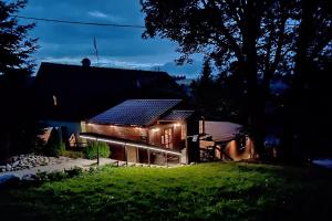 una casa con paneles solares en el techo por la noche en PENZION HARRY na sjezdovce KRKONOŠE, en Vysoké nad Jizerou