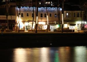 a building lit up at night with a body of water at Hotel Mac Rae in Avalon
