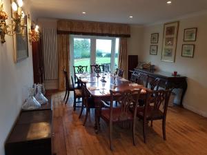 een eetkamer met een houten tafel en stoelen bij House On The Hill in Little Massingham
