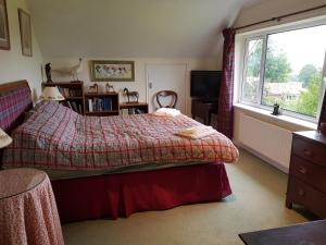 a bedroom with a bed and a window at House On The Hill in Little Massingham