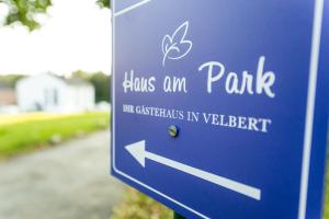 um sinal azul com uma seta a apontar para um parque em Haus am Park - Ihr Gästehaus in Velbert em Velbert