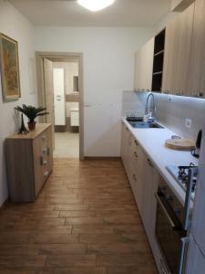 una cucina con banconi bianchi e pavimenti in legno di Guesthouse Škofije ob Parenzani a Spodnje Škofije