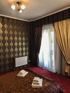 a room with a bed, table, and curtains at Garden Hall in Ternopil
