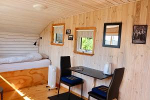 a room with a bed and a desk in a tiny house at Plexus Hytterne in Holstebro