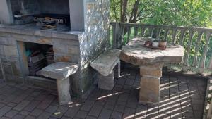 un tavolo in pietra e panche accanto a un camino di Guesthouse Škofije ob Parenzani a Spodnje Škofije