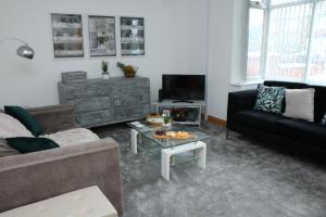 a living room with a couch and a coffee table at Ideal Lodgings in Bury - Whitefield in Bury