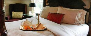 Una cama con una bandeja con un set de té. en The Inn at Stony Creek en Warwick