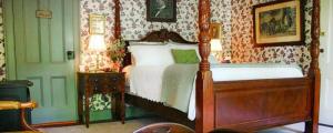 a bedroom with a bed with a wooden frame at The Inn at Stony Creek in Warwick
