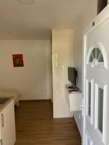 um quarto branco com uma televisão e uma porta em Apartments Boss em Budva