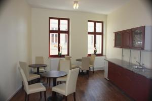 ein Esszimmer mit Tischen, Stühlen und Fenstern in der Unterkunft Gästehaus INNFernow in Fürstenberg-Havel