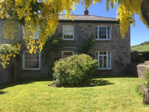 een oud bakstenen huis met een groene tuin bij Instow Barton in Instow