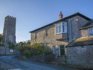 an old stone building with a tower on a street at Instow Barton in Instow