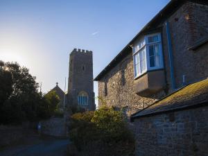 an old stone building with a tower and a window at Instow Barton in Instow