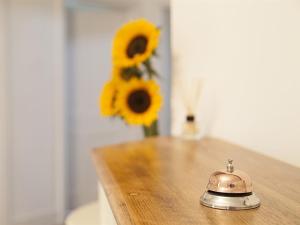 a tea kettle on a table with a vase of sunflowers at Instow Barton in Instow