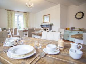 a dining room with a table with white dishes on it at Instow Barton in Instow