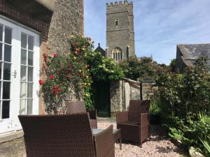 a group of chairs and a building with a tower at Instow Barton in Instow