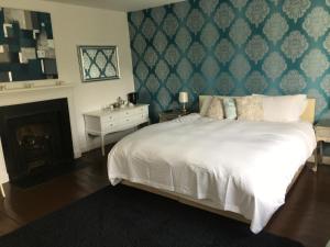 a bedroom with a large white bed and a fireplace at Instow Barton in Instow