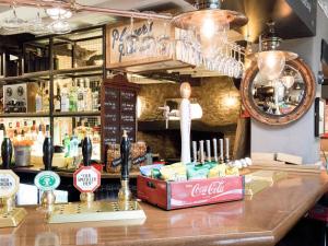 a bar with a coca cola sign on a counter at The Plough Bicester in Bicester