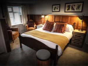 a bedroom with a large bed and a chair at The Plough Bicester in Bicester