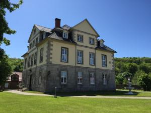 an old house with a grassy field in front of it at Jagdschloß Walkenried in Walkenried