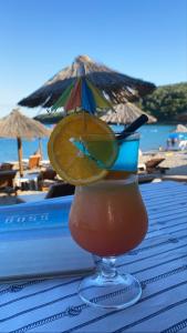 uma bebida num copo numa mesa na praia em Apartments Boss em Budva