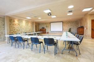 uma sala de conferências com uma grande mesa e cadeiras em Les Jardins de l'Abbaye em Simiane-la-Rotonde