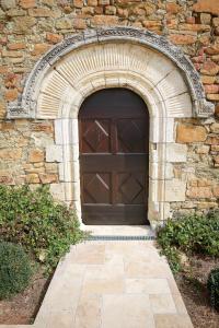 uma grande porta de garagem de madeira num edifício de pedra em Les Jardins de l'Abbaye em Simiane-la-Rotonde