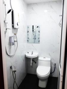 a white bathroom with a toilet and a sink at 28 Gred Hotel in Bukit Mertajam