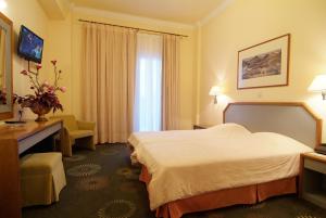 a hotel room with a bed and a desk at Hotel Kalafati in Itea