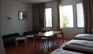 a hotel room with a table and chairs and a couch at Hostel am Kurtti in Berlin