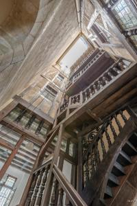 een oud gebouw met houten trappen en een plafond bij L'Oisellerie Meublé de Tourisme in Angers
