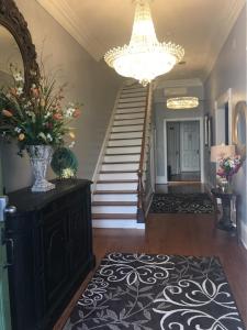 um corredor com uma escada e um vaso de flores sobre uma mesa em WG Creole House 1850 em Nova Orleans