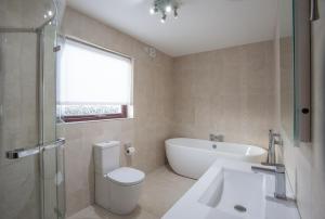 a bathroom with a toilet and a tub and a sink at Keef Halla Country House in Crumlin