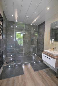 a large bathroom with a shower and a sink at Kentwood Guest House in Arnside