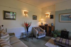 a living room with two couches and a table at Kentwood Guest House in Arnside