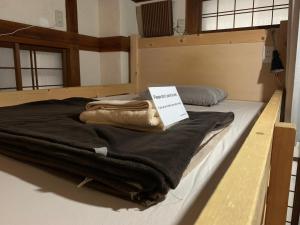 una cama con una manta negra y un libro sobre ella en FromScratch TOKYO, en Tokio